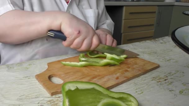 Uma Mulher Corta Uma Pimenta Doce Com Uma Faca — Vídeo de Stock