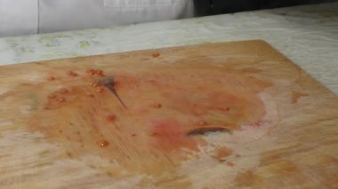 Bir kadın bıçakla domates kesiyor.