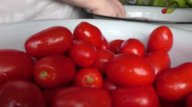 Aşçı suda yıkanır, kırmızı domatesler