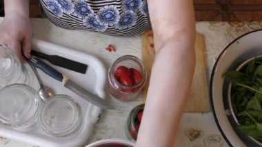 Kadın şef kırmızı domatesleri korur.