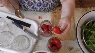 Kadın şef kırmızı domatesleri korur.