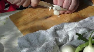 Kadın şef soğanları bıçakla doğruyor.