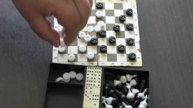 Bir adam dama oynar.