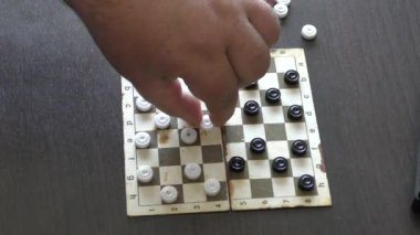 Bir adam dama oynar.