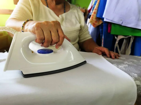 Woman ironing clothes on ironing board. Woman ironing clothes.Concept of ironing.