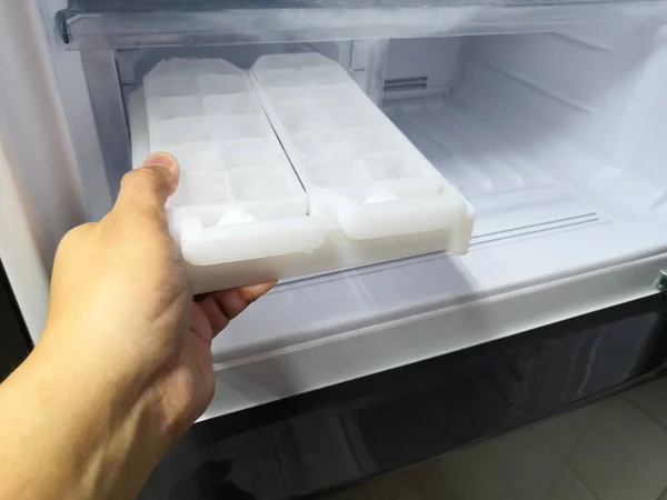 Yeni buzdolabında buz makinesi tutan adam el. Kapalı.