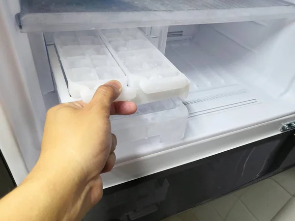 Yeni buzdolabında buz makinesinden buz için adam el büküm. Kapalı.