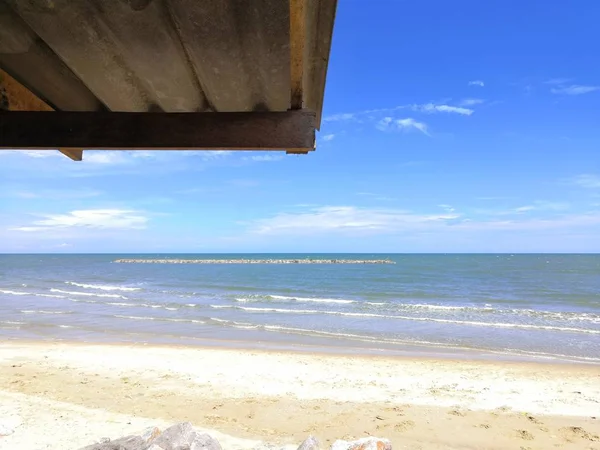 Bulutlar ve deniz arka plan ile ahşap bir çatı inşaatı.