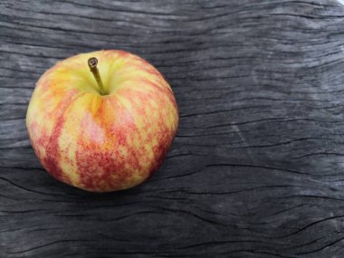 Eski ahşap masa arka plan üzerinde kırmızı elma.