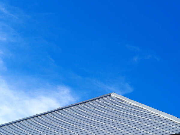 Slate roof and slope with clouds and blue sky background.Tile roof of construction house with blue sky and cloud background.