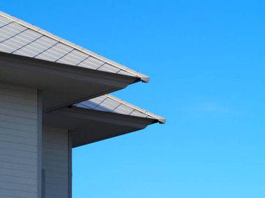 Mavi gökyüzü arkaplanı olan ev. Anlaşıldı. Çatı, bulut ve mavi gökyüzü arkaplan. Mavi gökyüzü ve bulut arkaplanlı inşaat evinin döşeme çatısı..