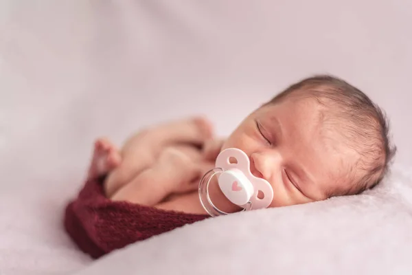 Nyfött barn med napp stoppad i en ullboll. Begreppet nyfödd — Stockfoto