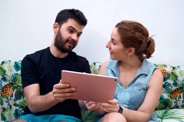 Couple choosing a holiday destination using a tablet. Concept of a holiday for two