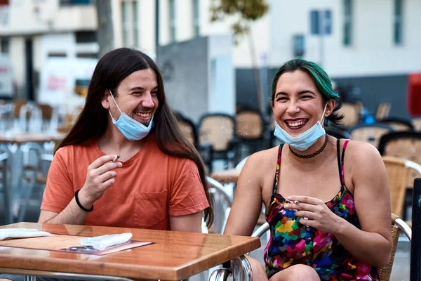 Bar terasında sigara içen genç bir çift. Kavram salgını