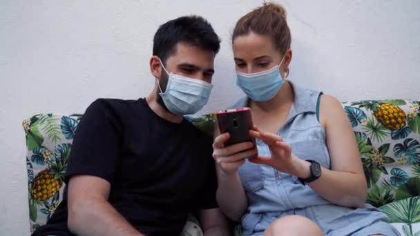 Jeune Couple Avec Des Masques Chirurgicaux Utilise Téléphone Portable Concept — Video