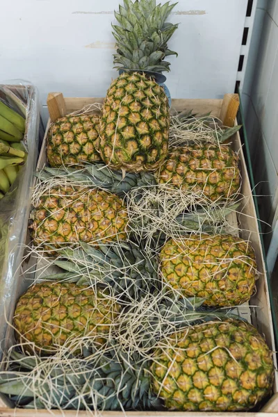 A pile of pineapples placed inside a wooden box. Healthy fruit concept