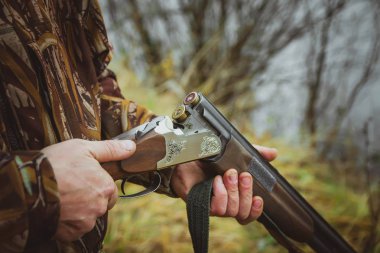 Rusya, Kholmogory-17 Ekim 2019 avcı sonbahar ormanında bir tüfek dolduruyor..