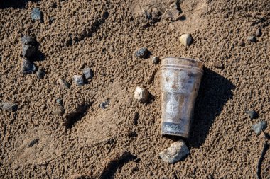 Plastik cam sahilde yatar ve denizi, nehri kirletir. Çöp, çöp, çöp, çevre kirliliği. Plastik denizlerin ve okyanusların kirlilik kontrolü kavramı.
