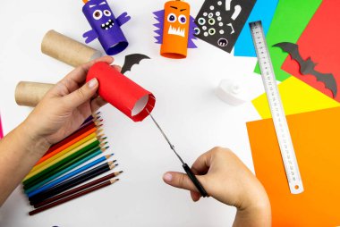 Cadılar Bayramı süsü. DIY ve çocukların yaratıcılık konsepti. Adım adım: Renkli tuvalet kağıdı rulosundan canavar yap. Üçüncü adım kesim yap.