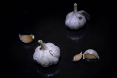 Siyah arka planda sarımsaklı ürün sergisi. Baharatlı sarımsaklı karanfil vitamin yiyeceği.