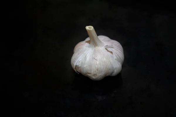 Garlic close-up product show on black background. Spice garlic clove vitamin food winter health eating