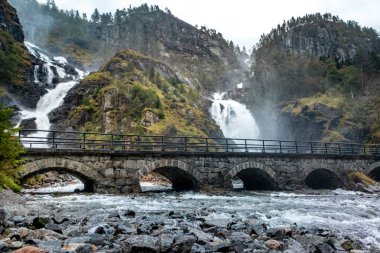Latefossen Şelalesi, taş köprüsü olan eşsiz bir şelale. Odda Vadisi 'nde ikiz şelale, Vestland İlçesi Ullensvang Belediyesi, Norveç