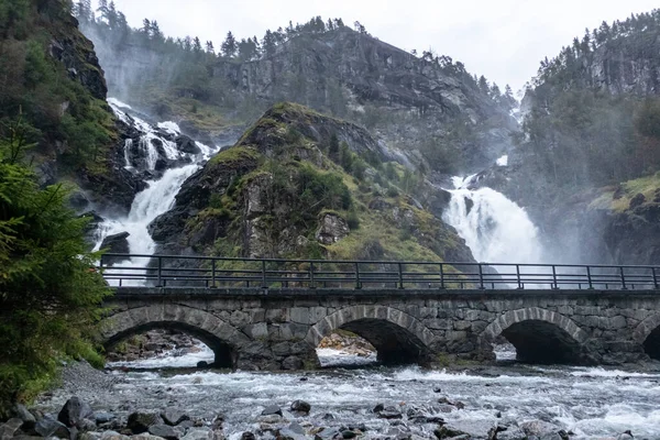 Latefossen Şelalesi, taş köprüsü olan eşsiz bir şelale. Odda Vadisi 'nde ikiz şelale, Vestland İlçesi Ullensvang Belediyesi, Norveç