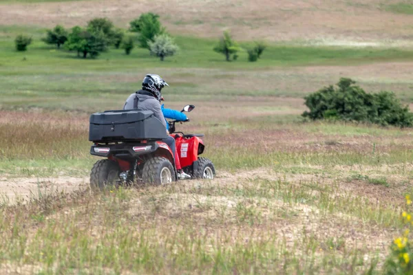 Riding quadbikes motorcycle in spring off-road fields in Kitsevka, Ukraine, Kharkiv region landscape. Distant off-road driving scenery