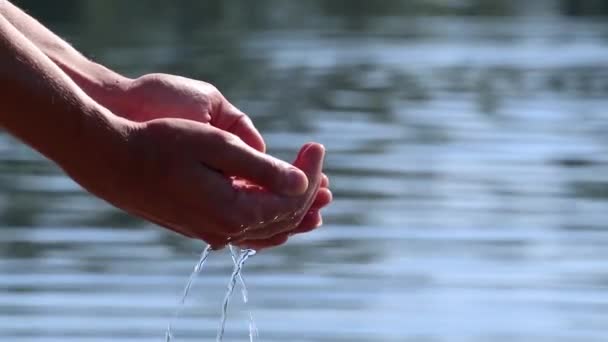 スローモーションを閉じる手の海の川の水をカッピングのループ 手で純水をつかむと 水面にゆっくりと落下します — ストック動画