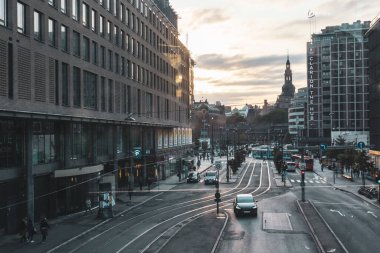 Oslo, Norveç - 10 Eylül 2019: Şehir merkezi demiryolu, modern ve eski binalar, gün batımında sıcak ve dramatik bulutlu gökyüzü ile kavşak