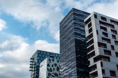 Oslo, Norveç - 10 Eylül 2019: Oslo 'nun modern ticaret bölgesi bulutlu destansı gökyüzünde. Bjorvika ilçesindeki Barkod projesinin ofis kentsel binaları