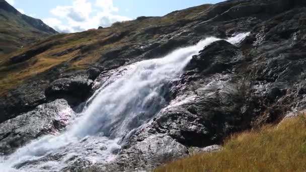 阳光明媚的白色风景 挪威强大的河流瀑布瀑布与黑暗的岩石和明亮的蓝天 大自然在清澈的落水景观中穿梭 从右到左 — 图库视频影像