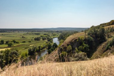 Tepeden uzaktaki nehir vadisinde yaz manzarası kuru çimlerin arasında. Ukrayna 'daki Siverskyi Donets Nehri' ndeki Zmiyevsky uçurumları