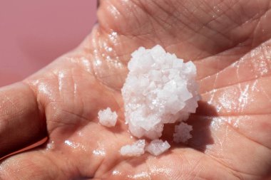 Pembe su yüzeyinin yakınında pembe beyaz tuz tanecikleri oluşmuş. Kaplıcaya yakın güneşli
