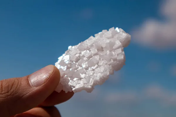 Die Hände Halten Weiße Glänzende Salzflocken Vor Verschwommenem Blauem Himmel — Stockfoto