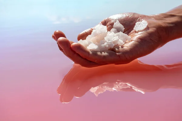 Mão Segurando Monte Cristais Flocos Sal Branco Rosa Acima Superfície — Fotografia de Stock