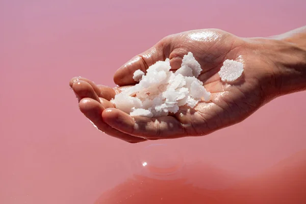Mão Segurando Monte Cristais Flocos Sal Branco Rosa Acima Superfície — Fotografia de Stock