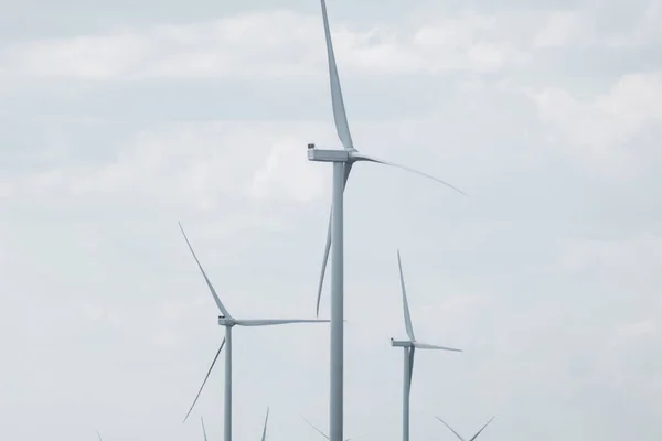 Wind generators farm sustainable industry. Cloudy color graded sky cloudscape with Energy turbines power
