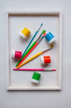 Beyaz çerçeveli beyaz arka plan üzerindeki Renklerle Renkli Boya Fırçaları. Dikey