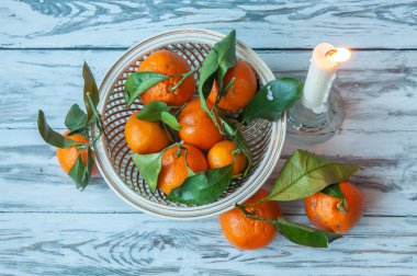 Beyaz ahşap arka plan üzerinde bir mum ve mandalina ile Noel veya Yeni Yıl kompozisyon.