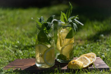 Limon ve nane likörü. Çimlerin üzerinde iki bardak var..