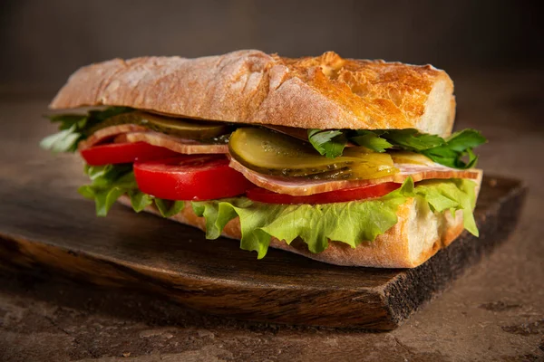 Ev yapımı ekmek, jambon, domates, marul ve salatalık turşusu.