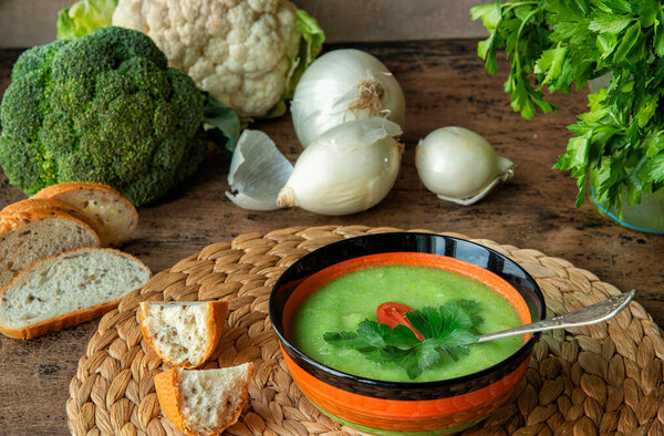 Broccoli and cauliflower soup with ingredients for making it. Horizontal