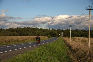 Sonbahar yolundaki yalnız motosikletçi.