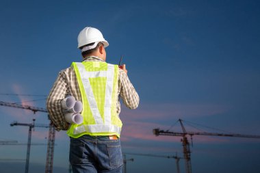 İnşaat mühendisleri inşaat projesinin ilerlemesini denetliyor.