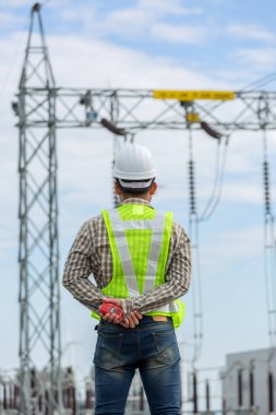 Elektrik mühendisi elektrik santralinin önünde çalışıyor ve duruyor..