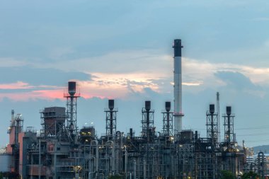 Endüstriden petrol rafinerisi, petrokimyasal petrol ve gaz rafinerisi ve gündoğumu gökyüzü arka planına sahip boru hattı endüstrisi