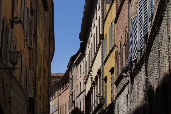 Old buildings inside one of the alleys of the town of Siena