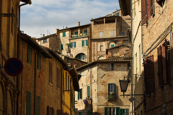 Old buildings inside one of the alleys of the town of Siena. High quality photo