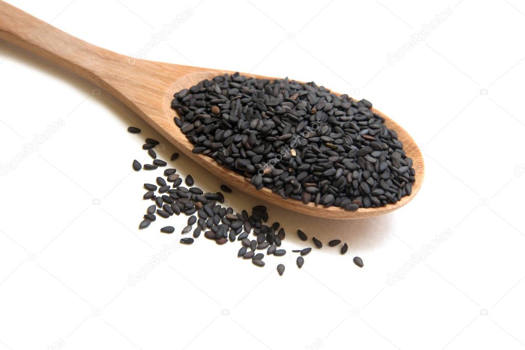 Heap black sesame seeds  close up shot on wooden spoon, isolated.